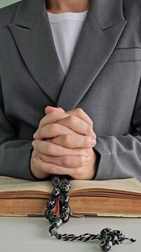 Hand of an human mullah holding rosary beads vertical 