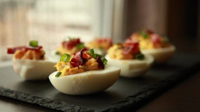  preparing delicious deviled eggs, topped with crispy bacon. A perfect party food idea 