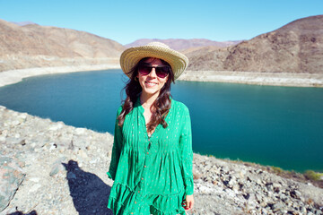 latin tourist woman posing outdoors in the Huasco valley with a damn in the background	