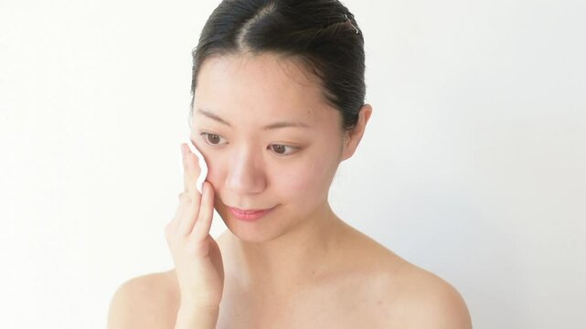 コットンで顔を押さえている女性