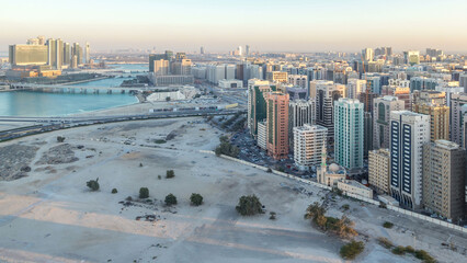 Aerial skyline of Abu Dhabi city centre from above day to night timelapse