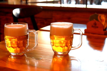 A glass of beer against background of blurred image of cafe, bar, restaurant, close-up. A foggy...