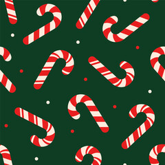 Seamless Christmas pattern with red and white candy cane on dark green background.