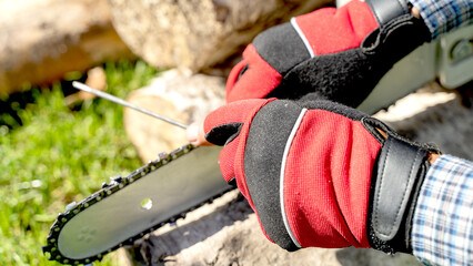 a master sharpens a chainsaw chain before work