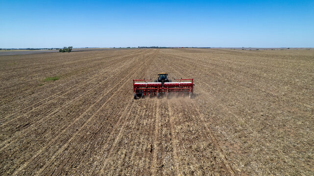 Agricultural mechanical seeders of grain crops. Tactor with a seeder sows grain in the field. A farmer on a tractor with a seeder processes the field.