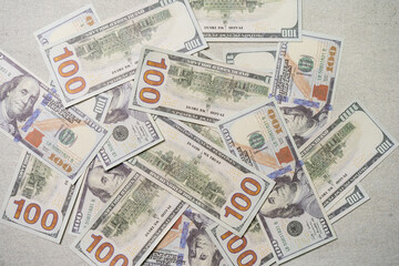 A US 100 dollar bill on top of a pile of scattered dollar bills, currency, texture and background.