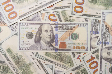 A US 100 dollar bill on top of a pile of scattered dollar bills, currency, texture and background.