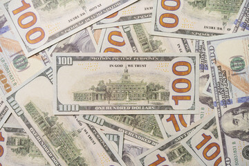 A US 100 dollar bill on top of a pile of scattered dollar bills, currency, texture and background.