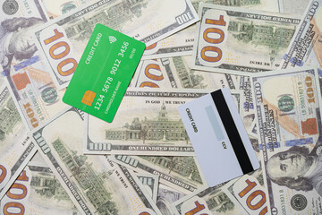 two credit cards on top of a pile of scattered dollar bills, texture and background.