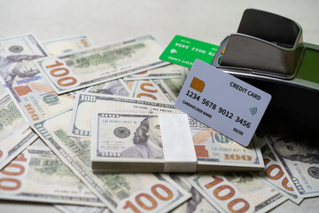 credit card and EDC machine on top of a stack of 100 US dollar bills, currency concept.