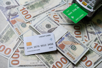 credit card and EDC machine on top of a stack of 100 US dollar bills, currency concept.
