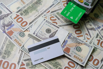credit card and EDC machine on top of a stack of 100 US dollar bills, currency concept.