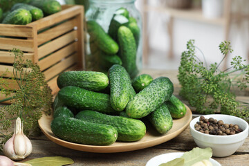 Fresh cucumbers, dill and spices on wooden table, closeup. Preparation for pickling