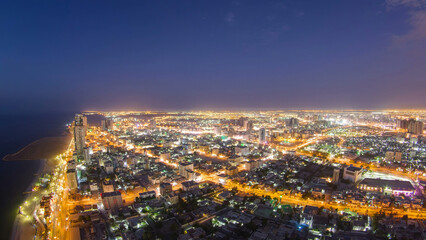 Cityscape of Ajman from rooftop day to night aerial timelapse