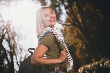 Photo of pretty young blonde woman backpack walking wear khaki clothes tied shoulders sweater...