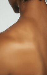 Back View of Woman's Shoulder and Upper Back, Emphasized by Low-Angle Perspective and Soft Lighting