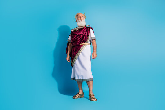Full length photo of attractive old man strong confident pose dressed greek god emperor actor costume isolated on blue color background