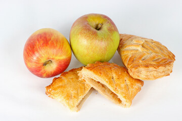 French apple turnovers with two whole apples on a white background