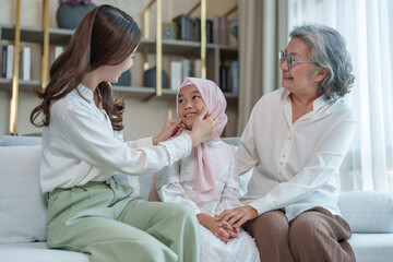 Fototapeta premium A child girl wear hijab with mother visit her grandma at home,happy asian family in the living room