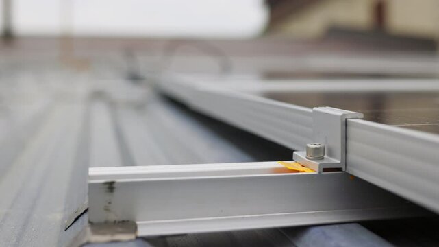 Close up of mounting solar panel, installing solar panels on dau house. Fixing and connection of modern solar panels. Rows of sustainable energy solar panels installed on terrace.