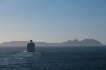 Classic British cruiseship cruise ship liner Ambience sail away departure from port of Vigo, Spain in Galicia during summer Atlantic Coast cruising with blue sky and coast line