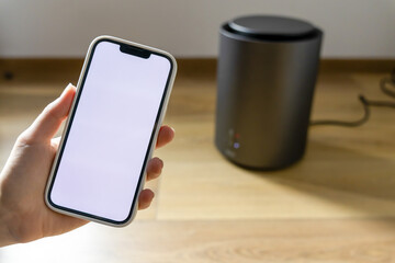 Woman setting up a heater through the smart home app. Miniature heater. Temperature control. White...