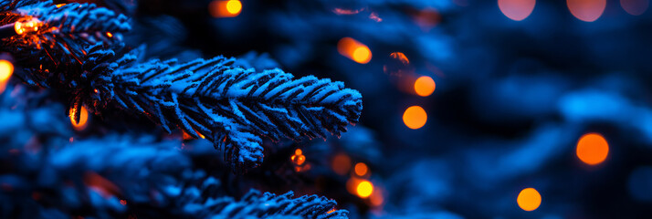 Naklejka premium A close up of snow covered pine branches adorned with warm orange lights creates magical winter atmosphere. contrast of blue and orange evokes cozy holiday feeling