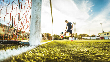 Professional football kicking ball in soccer stadium - Athletic man training sport outside - Concept about sports, competition, motion, overcoming