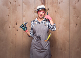 Call me, gardener woman holding pruning shears gesturing at speaking on phone while looking to...