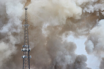 Communication Tower Amidst Smoke Plumes Eye-Level Perspective