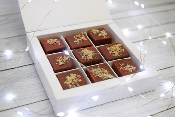 chocolat candies packed in a white box near glowing lights