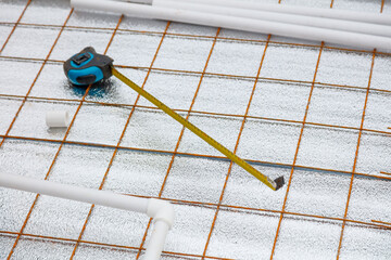 A tape measure is laying on a metal grid