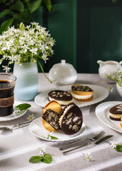 Delicious easter egg shaped cookies with white chocolate filling and almonds on festive table setting