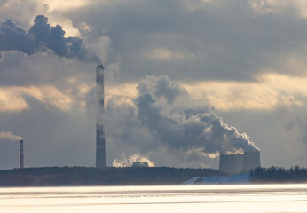 A large industrial plant is emitting smoke into the sky