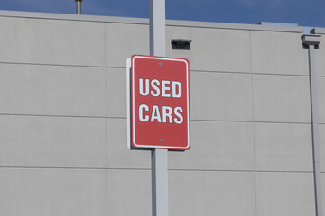 USED CARS sign at a dealership. With pricing issues, used and preowned cars are in high demand.