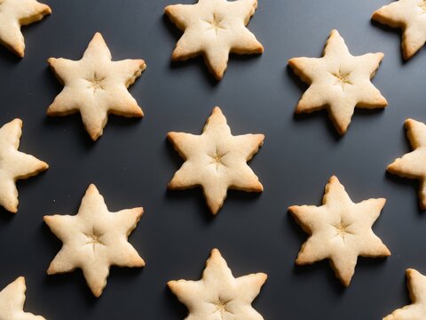Eight golden star shaped cookies on black background top view festive celebration.