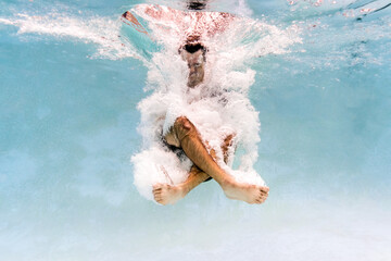 Man swimming underwater in a pool 