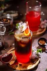 Refreshing espresso and tonic cocktail with blood orange and blossom garnish