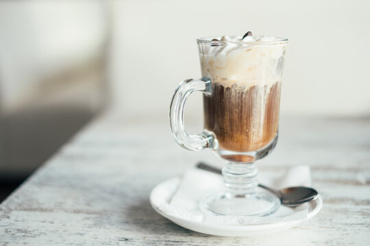 Close-up of an Irish coffee with whipped cream on a wooden table