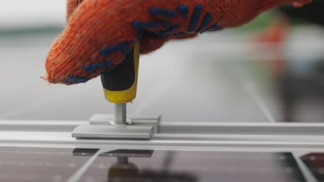 Close-up Installation, Connection and mounting of solar panels. Workers fasten solar panels. Technicians installing solar panels on metal stand. Workers installing solar panels on the roof of a house.
