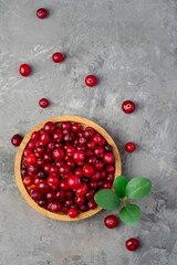 Cranberries in a wooden bowl on a dark background. top view, free space. Vitamins, benefits.