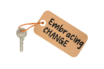 Key to Embracing Change Concept Idea Metaphor Text on Brown Paper Label with Door Key Isolated on White Background