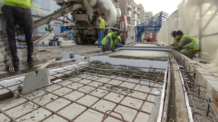 Pouring ready-mixed concrete after placing steel reinforcement to make the road by concrete mixer...