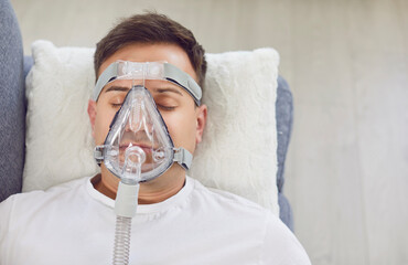 Sick man with a disease is sleeping at home, wearing an oxygen mask to manage asthma. His medical...