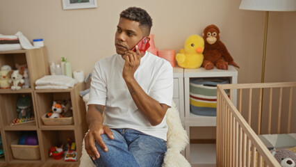 Young man talking on phone in bedroom next to baby's cradle surrounded by toys and stuffed animals