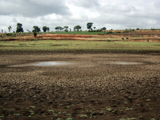 A dried lake in Karnataka, India, with cracked earth landscape. desertification in photo, climate...