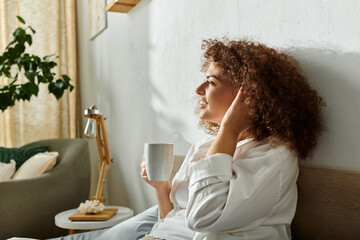 A woman sits comfortably in her stylish living area, savoring a warm beverage.