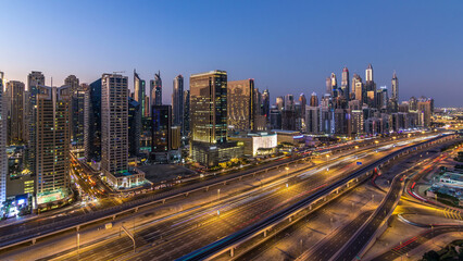 Dubai marina with traffic on sheikh zayed road panorama day to night timelapse lights turn on.