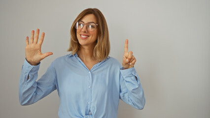 Smiling young woman with glasses counting six against an isolated white background