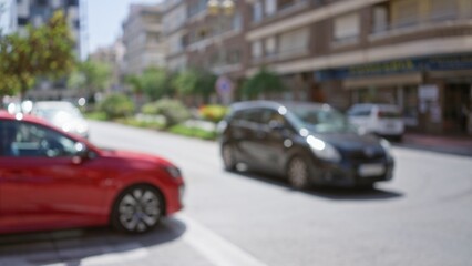 Blurred cars on a city street with buildings in the background and trees lining the sidewalk on a sunny day